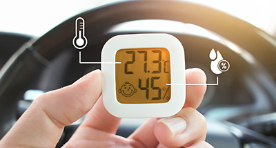 hand holding a digital thermometer displaying 27.3 degrees Celsius and 45 percent humidity inside a vehicle showing temperature and humidity levels important for car climate control and comfort 9 features