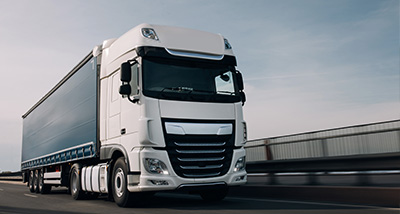 large white truck driving on highway with trailer featuring modern design and cargo capacity for transportation 14 wheels and 14 tons of load
