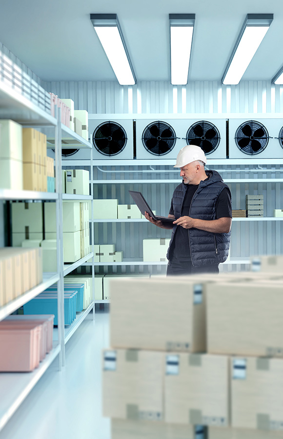 man using laptop in warehouse with boxes and shelves highlighting efficient inventory management and organization in a modern storage facility 9 optimized solutions