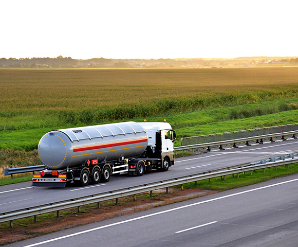 truck transporting liquid on highway with green fields in background showcasing logistics and transportation efficiency