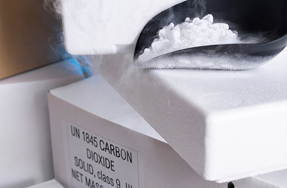 dry ice being poured from a container with visible vapor and a label indicating carbon dioxide solid for safe handling and storage in cold applications 2 methods 2 uses
