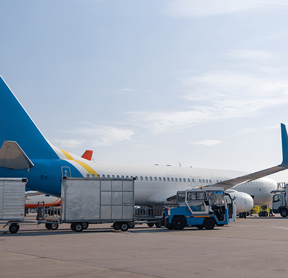 airplane at airport with luggage carts and ground service vehicles in clear sky transporting cargo and passengers for two flights